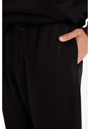 Defacto - Regular Fit Beli Bağcıklı Cepli Paçası Lastikli Şardonlu Basic Düz Jogger Eşofman Altı E6326AX25AU Siyah Defacto - Regular Fit Beli Bağcıklı Cepli Paçası Lastikli Şardonlu Basic Düz Jogger Eşofman Altı E6326AX25AU Siyah